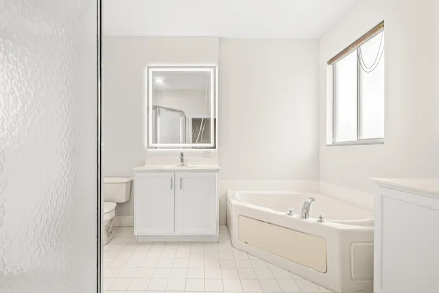 a bathroom with a bathtub sink and mirror