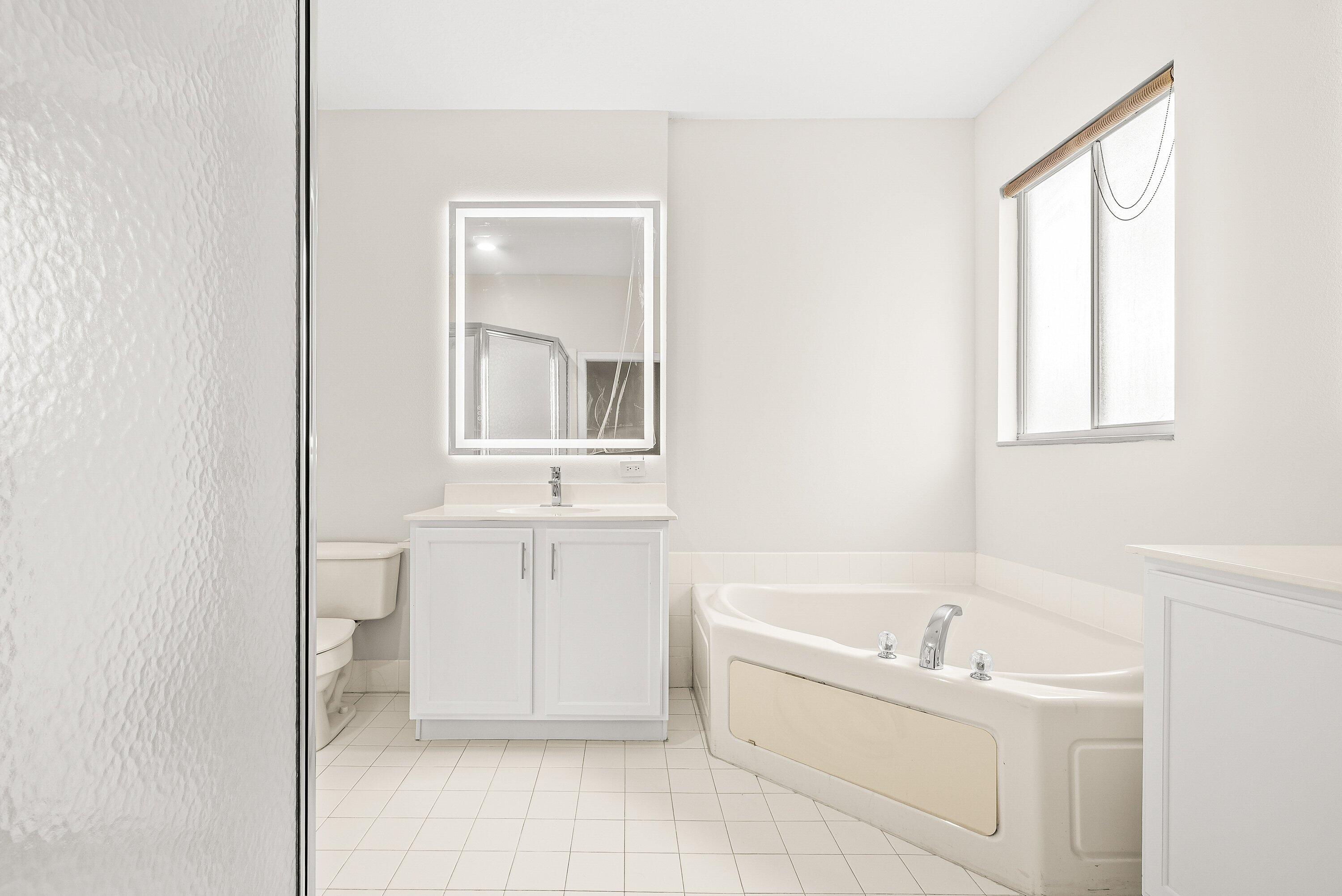 3187 North Oasis Drive Boynton Beach, FL 33426 - Photo 23 of 41 a bathroom with a bathtub sink and mirror