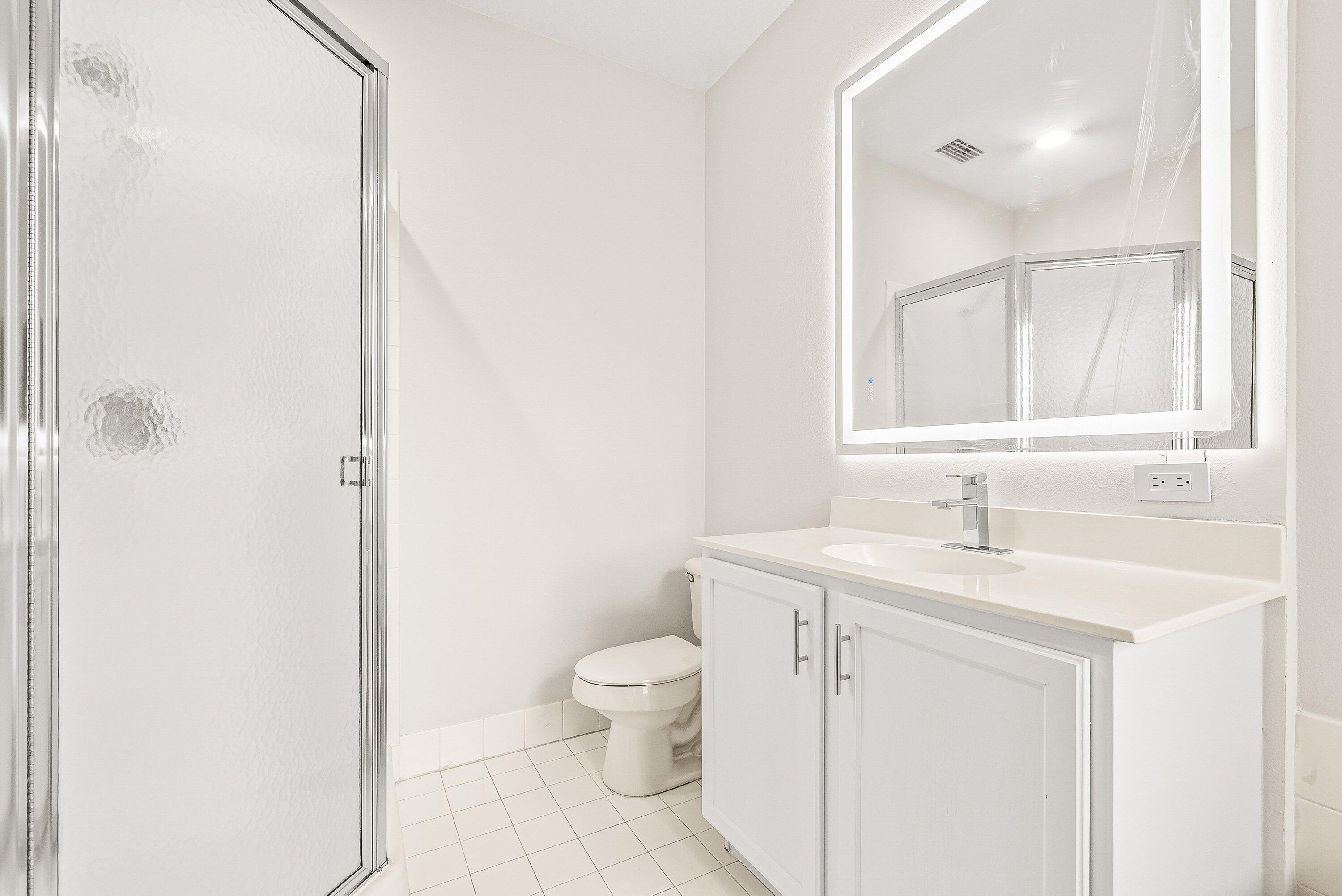 3187 North Oasis Drive Boynton Beach, FL 33426 - Photo 24 of 41 a bathroom with a toilet sink and mirror