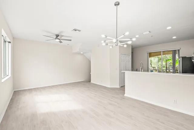 a view of a livingroom with a ceiling fan window and hardwood floor