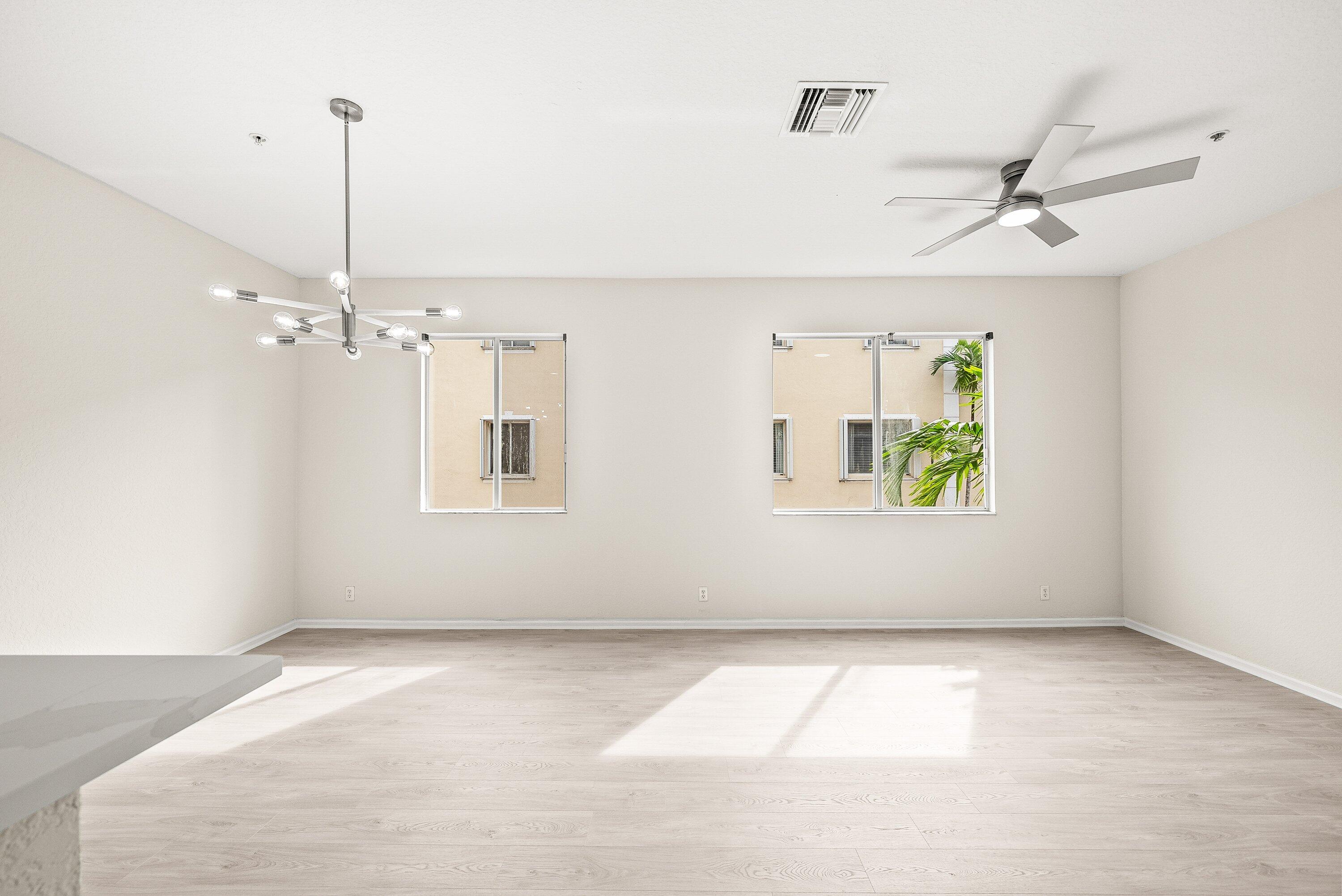 3187 North Oasis Drive Boynton Beach, FL 33426 - Photo 8 of 41 an empty room with windows and ceiling fan