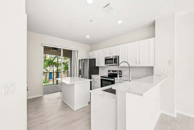 a kitchen with sink a microwave and refrigerator