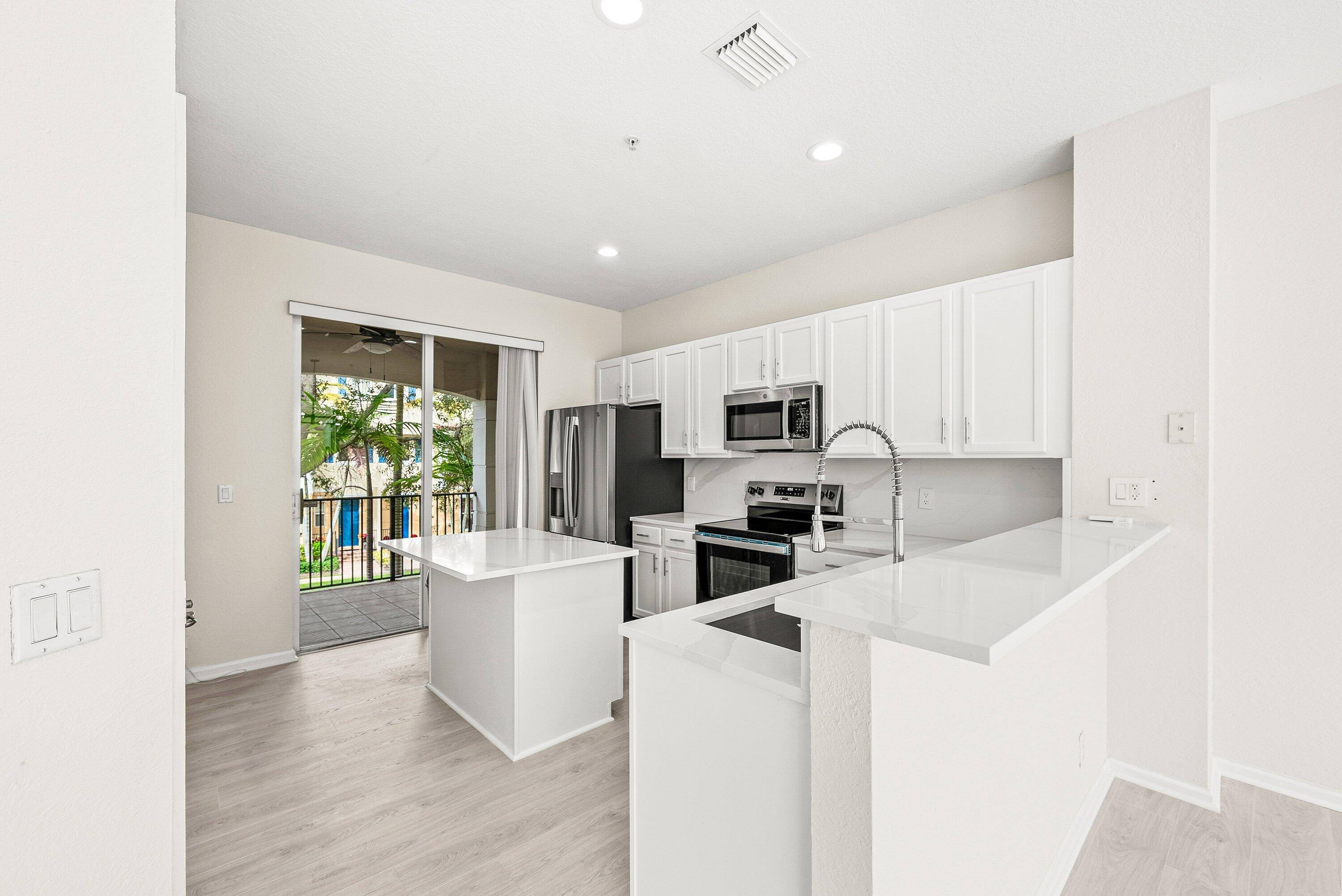 3187 North Oasis Drive Boynton Beach, FL 33426 - Photo 9 of 41 a kitchen with sink a microwave and refrigerator