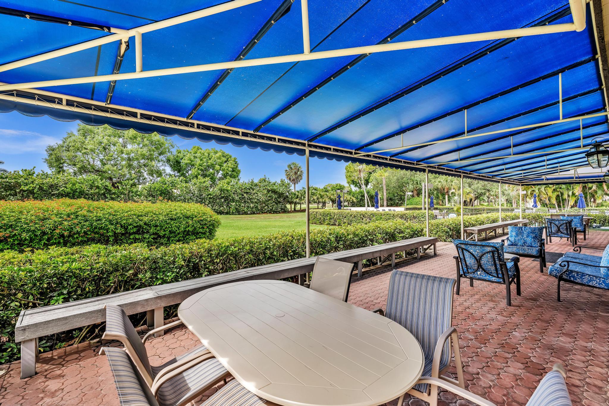 6320 Boca Del Mar Drive, Unit 303 Boca Raton, FL 33433 - Photo 42 of 42 a view of a patio with table and chairs potted plants with wooden floor and fence