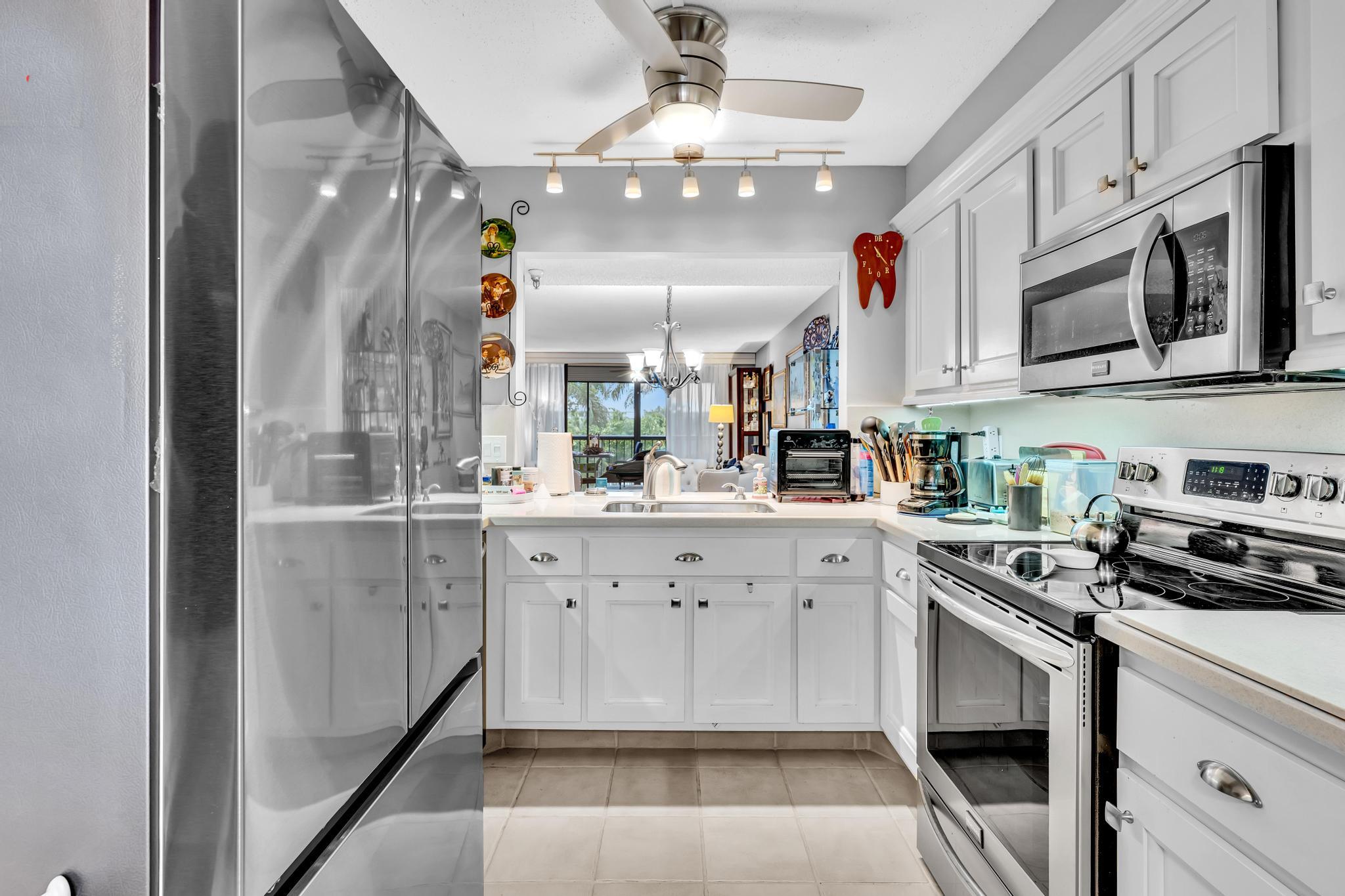 6320 Boca Del Mar Drive, Unit 303 Boca Raton, FL 33433 - Photo 6 of 42 a kitchen with stainless steel appliances granite countertop a stove a sink and a refrigerator
