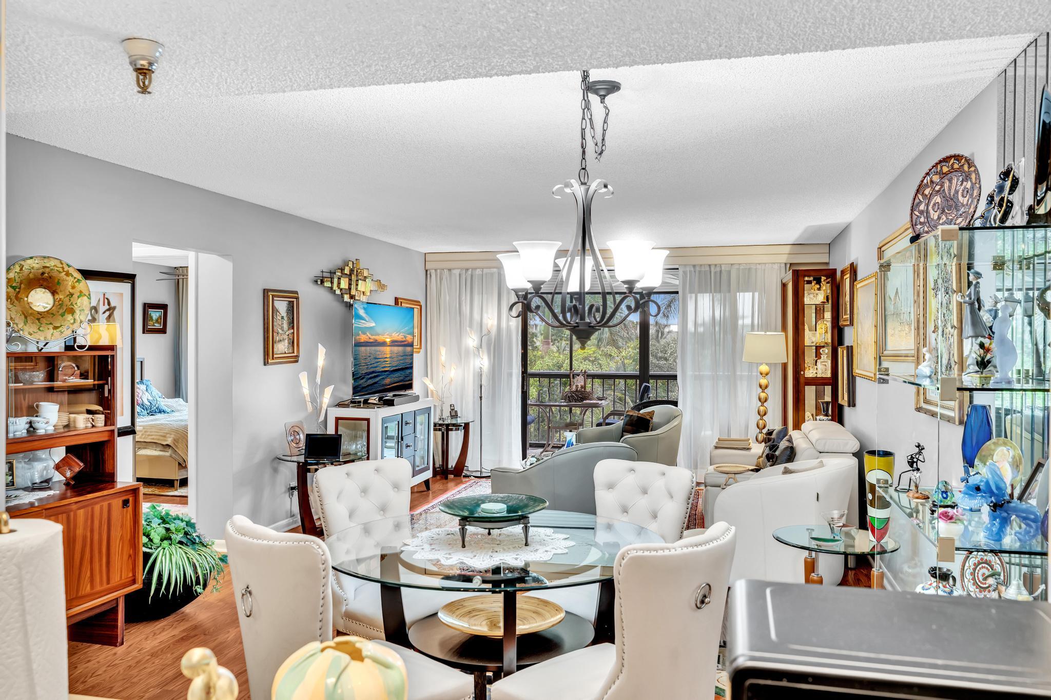 6320 Boca Del Mar Drive, Unit 303 Boca Raton, FL 33433 - Photo 9 of 42 a living room with lots of furniture and a chandelier