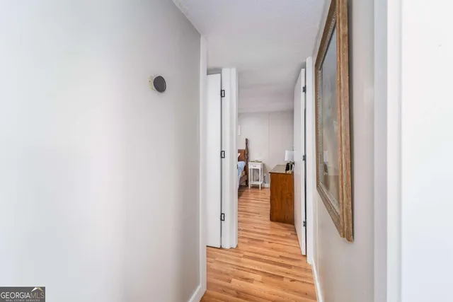 a view of a hallway with wooden floor and staircase