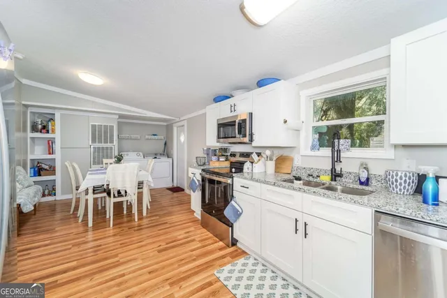 a kitchen with a dining table chairs and white appliances
