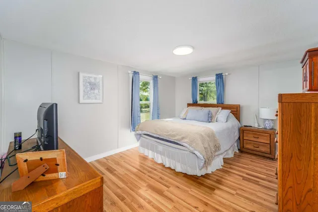 a bedroom with a bed and wooden floor