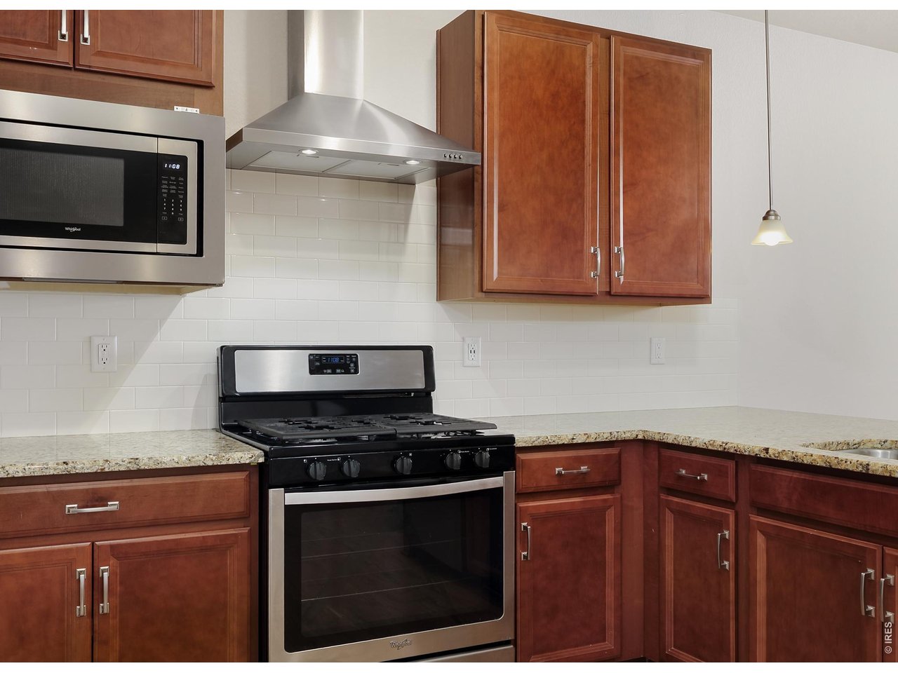 610 Stonebridge Drive Longmont, CO 80503 - Photo 11 of 30 a kitchen with granite countertop cabinets stainless steel appliances and wooden floor