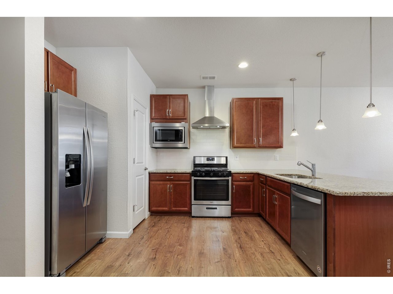 610 Stonebridge Drive Longmont, CO 80503 - Photo 7 of 30 a kitchen with stainless steel appliances granite countertop a refrigerator a sink dishwasher a stove with wooden cabinets