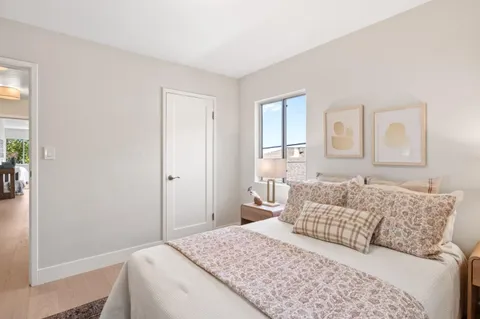 a bedroom with a bed and a large window