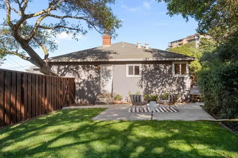 a view of a house with a yard and sitting area