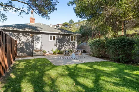 a view of a back yard of the house with a patio