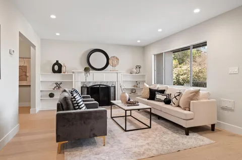 a living room with furniture a fireplace and a large window