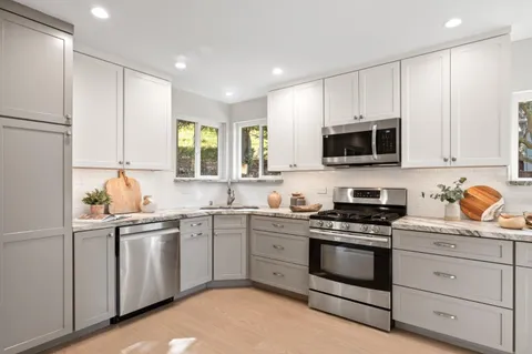 a kitchen with white cabinets sink and white appliances