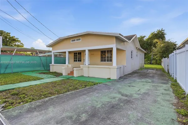 a view of backyard of house with green space