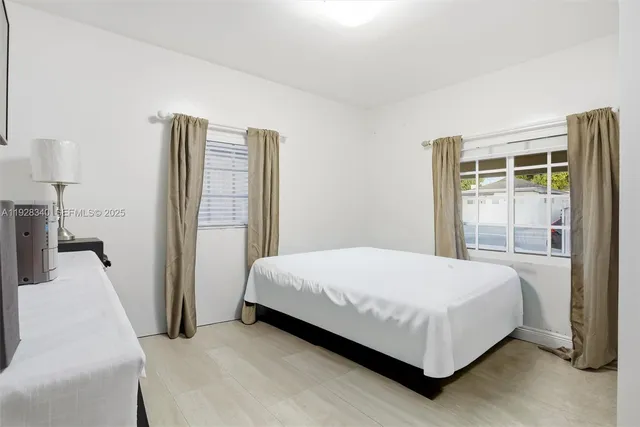 a bedroom with a bed and a large window