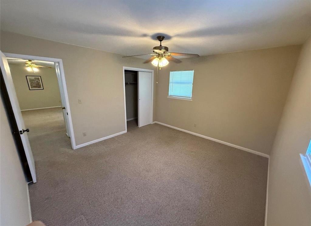 105 West Elm Gustine, TX 76455 - Photo 13 of 21 an empty room with a chandelier fan and wooden floor