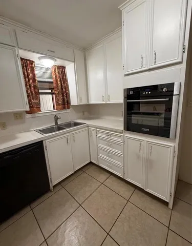 a kitchen with granite countertop white cabinets and white appliances