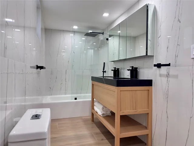a bathroom with a tub a sink and a shower