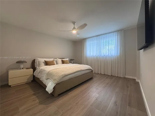 a spacious bedroom with a bed and a flat screen tv