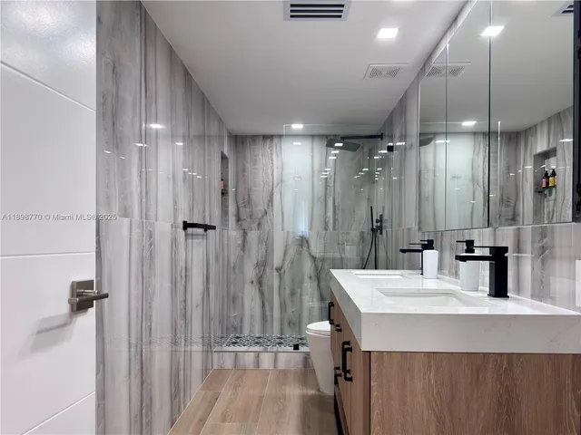 a bathroom with a sink a shower a mirror and a bathtub