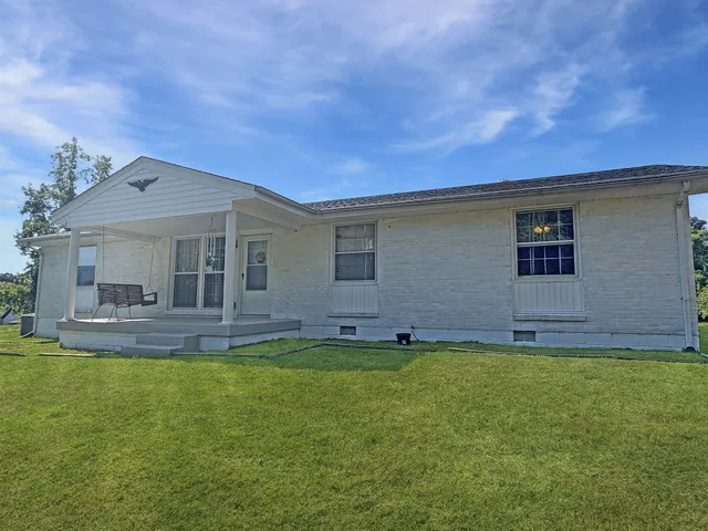 a backyard of a house with table and chairs