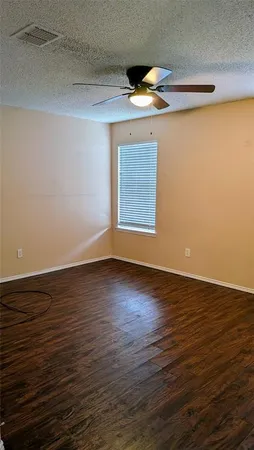 a view of an empty room with wooden floor and closet