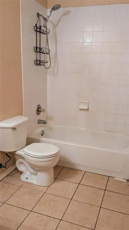 a view of an empty room with wooden floor and a ceiling fan