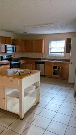a kitchen with a sink a stove cabinets and counter space