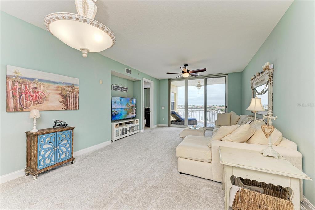 610 Riviera Dunes Way, Unit 406 Palmetto, FL 34221 - Photo 15 of 49 a spacious bedroom with a bed a couch and a flat screen tv