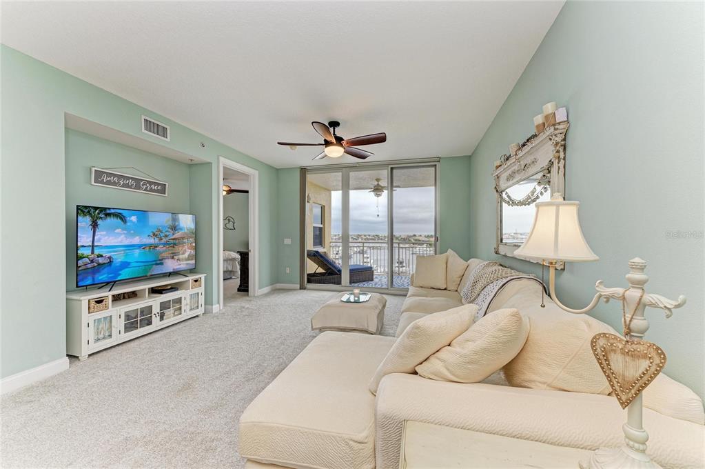 610 Riviera Dunes Way, Unit 406 Palmetto, FL 34221 - Photo 16 of 49 a living room with furniture a flat screen tv and a large window
