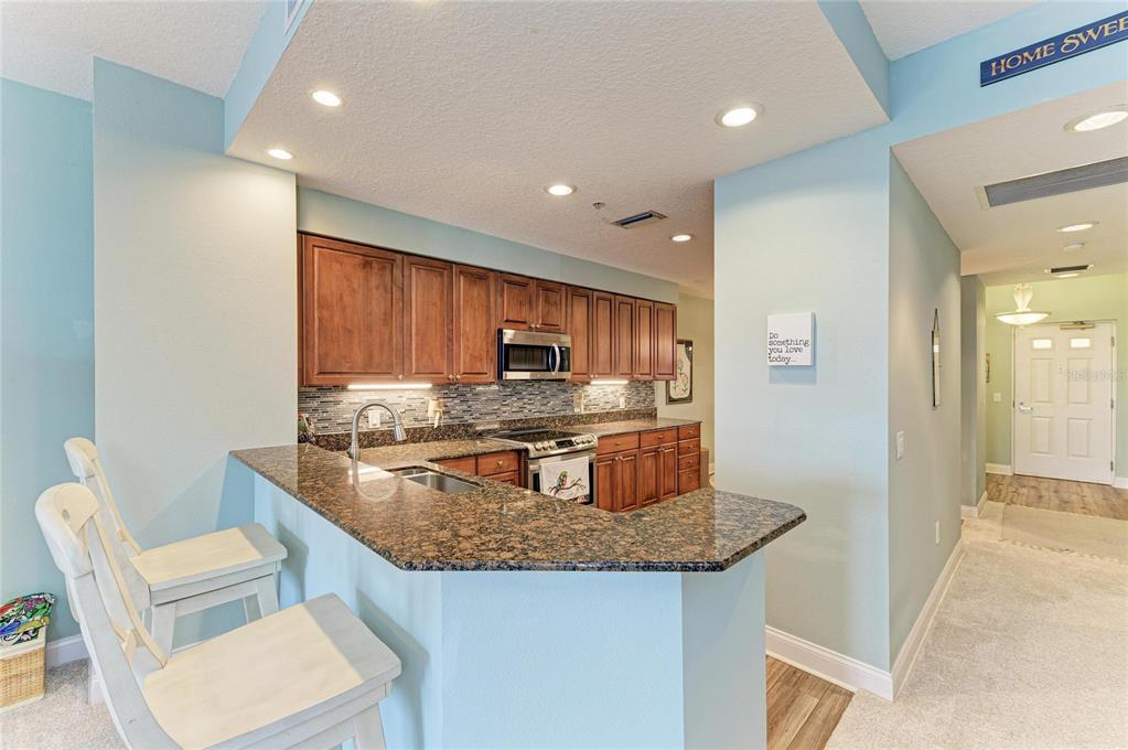 610 Riviera Dunes Way, Unit 406 Palmetto, FL 34221 - Photo 21 of 49 a kitchen with stainless steel appliances granite countertop a sink and a refrigerator