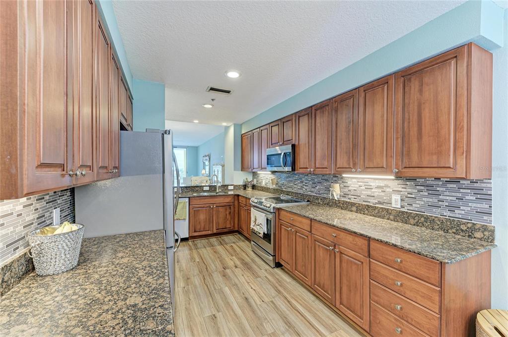 610 Riviera Dunes Way, Unit 406 Palmetto, FL 34221 - Photo 25 of 49 a kitchen with stainless steel appliances granite countertop a sink stove and cabinets
