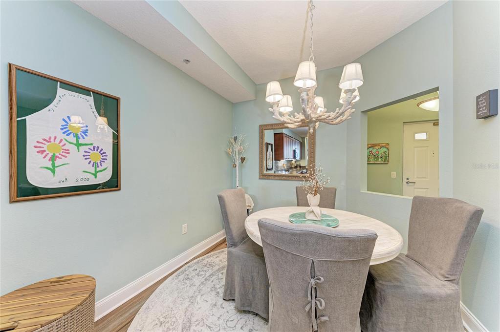 610 Riviera Dunes Way, Unit 406 Palmetto, FL 34221 - Photo 27 of 49 a dining room with a mirror and a chandelier