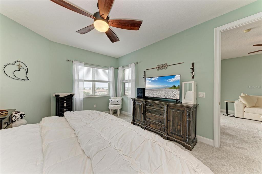610 Riviera Dunes Way, Unit 406 Palmetto, FL 34221 - Photo 29 of 49 a bedroom with a bed and a flat tv screen on dresser