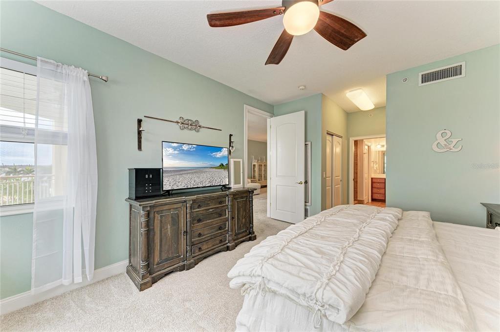 610 Riviera Dunes Way, Unit 406 Palmetto, FL 34221 - Photo 30 of 49 a bedroom with a bed and a flat screen tv
