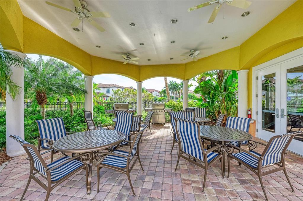 610 Riviera Dunes Way, Unit 406 Palmetto, FL 34221 - Photo 49 of 49 a view of a patio with a table chairs and a backyard