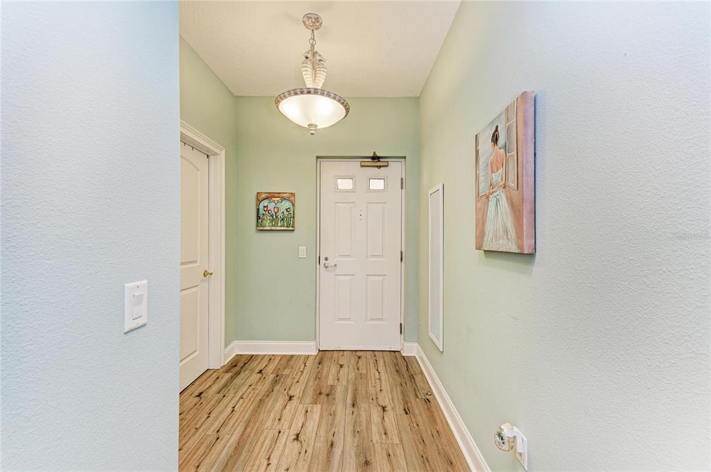 610 Riviera Dunes Way, Unit 406 Palmetto, FL 34221 - Photo 9 of 49 a view of a hallway with wooden floor and a bathroom
