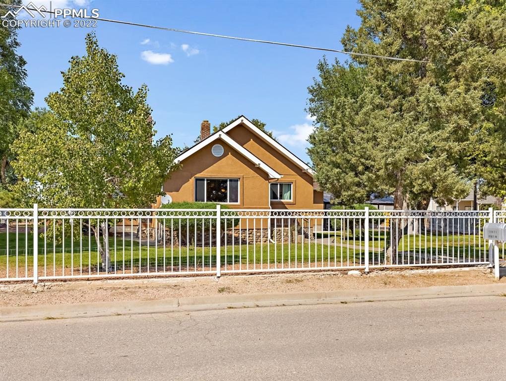 28021 Everett Road Pueblo, CO 81006 - Photo 3 of 43 Front exterior with metal decorative fence visible.