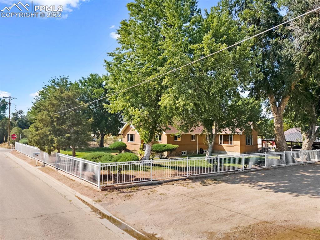 28021 Everett Road Pueblo, CO 81006 - Photo 4 of 43 Exterior with metal decorative fence and driveway visible.