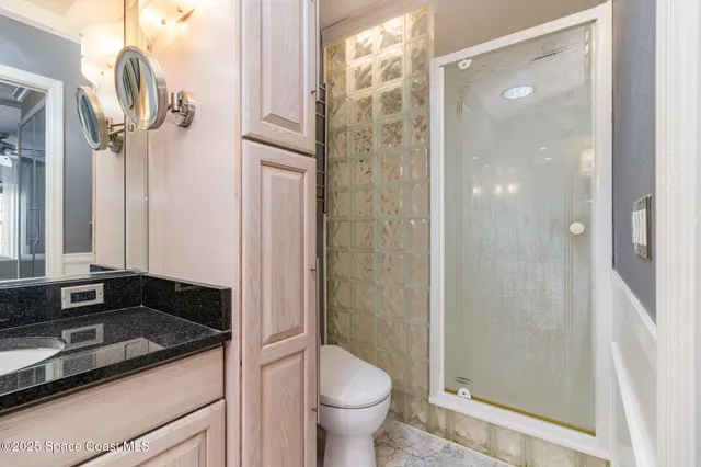 a bathroom with a granite countertop sink toilet and shower