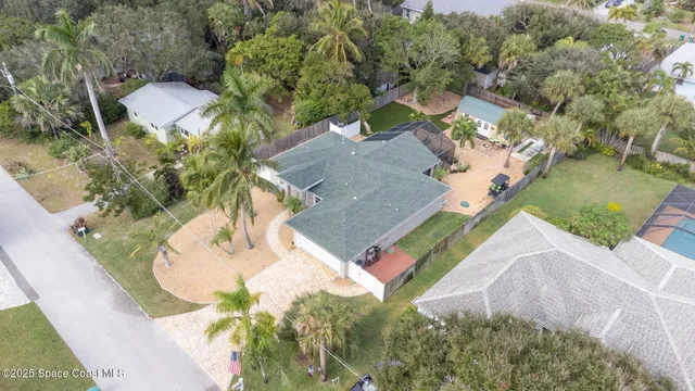 an aerial view of a house with a yard and lake