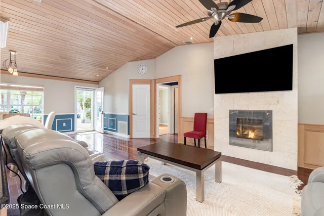 a living room with furniture a flat screen tv and a fireplace