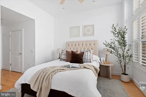 a bedroom with a large bed and a potted plant