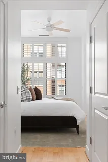 a bedroom with a bed lamp and a large window