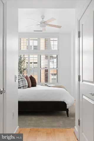 a bedroom with a bed lamp and a large window