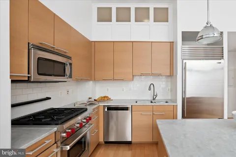 a kitchen with stainless steel appliances granite countertop a stove a sink and a microwave