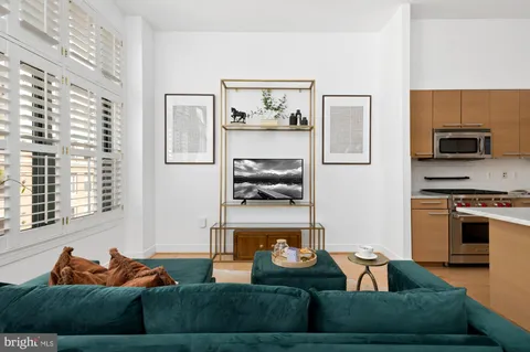 a living room with furniture and a kitchen area